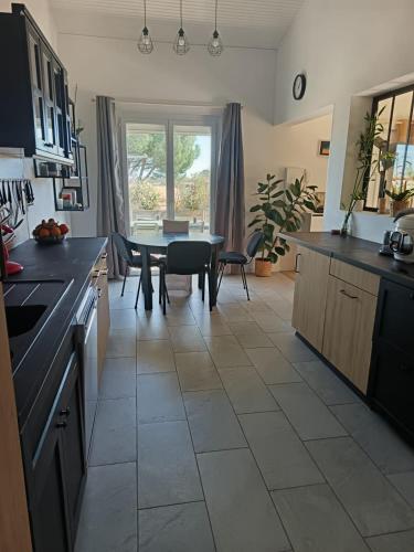 une cuisine avec une table et une salle à manger dans l'établissement Apparement Duplex avec jacuzzi, à Saint-Georges-dʼOrques