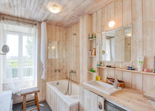 une salle de bain avec une baignoire et un lavabo dans l'établissement Charmant cottage normand avec vue panoramique sur la côte de Regnéville, à Regnéville-sur-Mer