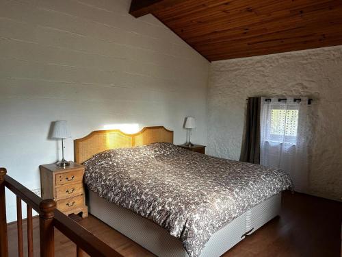 une chambre avec un grand lit et une fenêtre dans l'établissement Le Moulin à Eau, cœur Occitanie, à Laurabuc