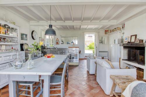 une cuisine et un salon avec une table et des chaises dans l'établissement Charmant cottage normand avec vue panoramique sur la côte de Regnéville, à Regnéville-sur-Mer