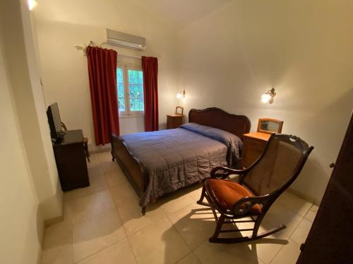 a bedroom with a bed and a chair in it at Casa RINCON DEL SOL in Villa la Bolsa