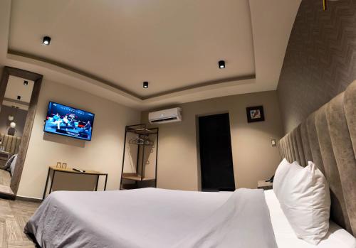 a bedroom with a bed with a tv on the wall at Hotel Capitalino in Pachuca de Soto