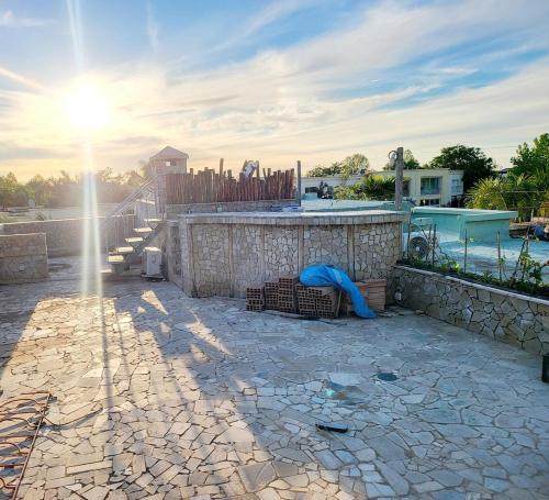 a stone patio with a stone wall and a hot tub at Duplex Reposant avec piscine au Andalines Golf Royal Fès in Dar Ito Lahssene