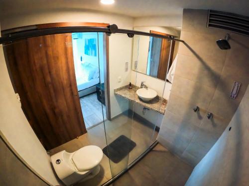 a bathroom with a toilet and a sink and a shower at Santorini Apartamentos Amoblados in Pereira