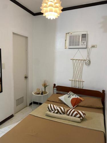 een slaapkamer met een bed met airconditioning aan de muur bij Happy Feet Siargao Homestay -General Luna in General Luna