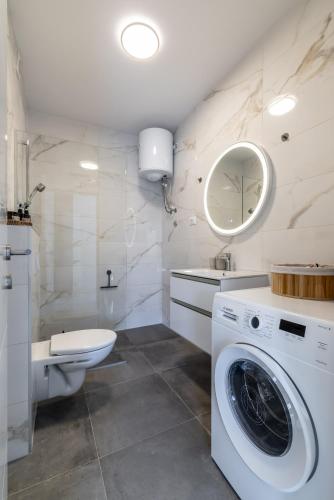 a bathroom with a washing machine and a toilet at Cocco e Limone in Sutivan