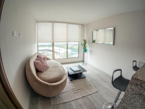 a living room with a chair and a table at Santorini Apartamentos Amoblados in Pereira