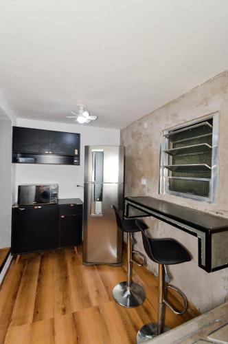 a kitchen with a desk and a stainless steel refrigerator at Casa com Garagem in Guarulhos
