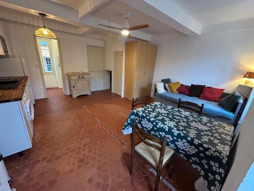 un salon avec un canapé et une table dans l'établissement Bormes village médiéval, à Bormes-les-Mimosas