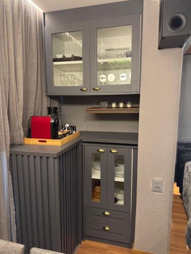 a kitchen with a cabinet with glass doors at Estúdio de Luxo Essenza in São Paulo
