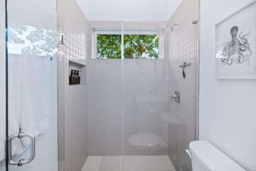 a white bathroom with a shower and a toilet at New-Dog Friendly,Hot Tub, Fire-pit, 1 mile to DTWN in Saint Augustine