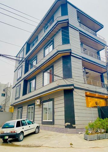 a building with a car parked in front of it at Doveinn Hotel R1 in Lahore