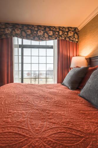 a bedroom with a large bed with a large window at Red Coach Inn in Niagara Falls