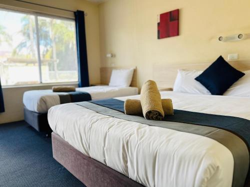 a hotel room with two beds and a window at Red Chief Motel in Gunnedah