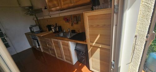 een kleine keuken met houten kasten en een spoelbak bij Villa pied dans l eau in Cala dʼOro