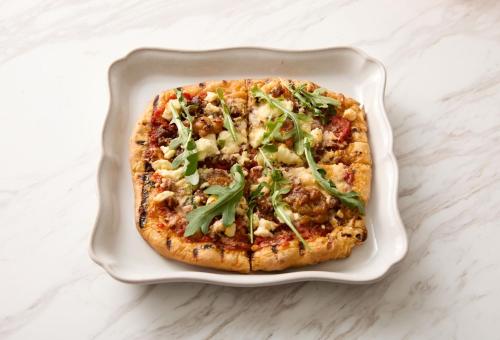 a pizza in a white dish on a table at InterContinental Indianapolis by IHG in Indianapolis