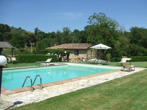 a swimming pool with chairs and a house at Borgo del Molinello in Sant'Albino