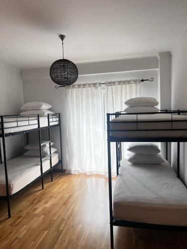two bunk beds in a room with a window at Ilumina Hostel Albufeira in Albufeira