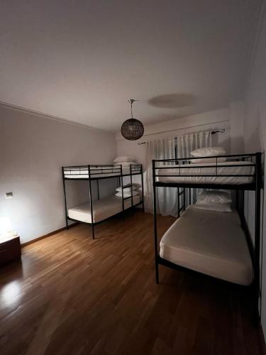 two bunk beds in a room with a wooden floor at Ilumina Hostel Albufeira in Albufeira