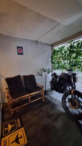a motorcycle parked in a room with a couch at Casa com Garagem in Guarulhos