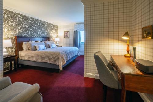 a hotel room with a bed and a desk and a desk at Red Coach Inn in Niagara Falls