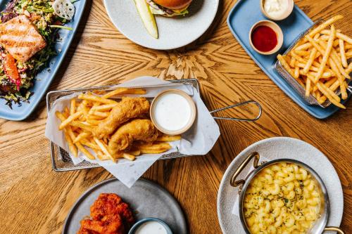 シアトルにあるAstra Hotel, Seattle, a Tribute Portfolio Hotel by Marriottの食器とフライドポテトをトッピングしたテーブル
