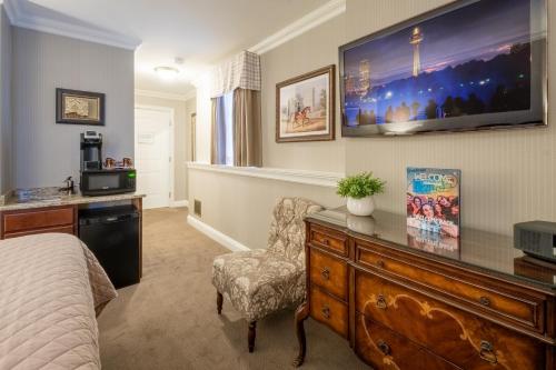 a bedroom with a bed and a dresser with a tv at Red Coach Inn in Niagara Falls