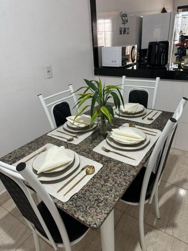 a dining room table with plates and utensils on it at Cantinho Girassol na Serra da Canastra in São Roque de Minas
