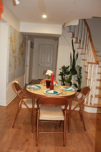 a dining room table with chairs and a staircase at Serene Don River Nature gateway- 2BR suite, Private Patio, Free Parking in Toronto