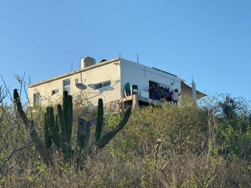 a group of people standing outside of a building on a hill at Casa sierra de la Laguna in Salalito