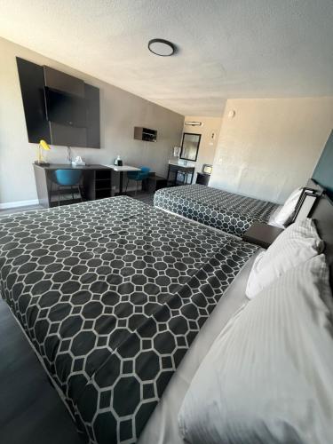 a hotel room with two beds and a desk at American Inn Port O'Connor in Port O'Connor