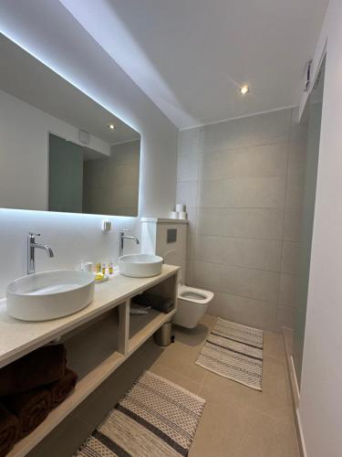 a bathroom with two sinks and a toilet at Moorea Sunset Beach in Haapiti