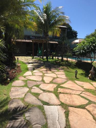 ein Steinweg vor einem Resort mit Palmen in der Unterkunft Casa linda in Goiânia