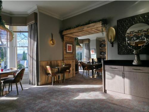 a living room with a table and a dining room at Beaufort Hotel in Inverness