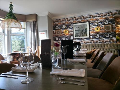 a restaurant with a long table with wine glasses at Beaufort Hotel in Inverness