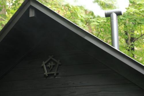 a cross on the roof of a black house at COCO VILLA Yatsugatake in Hokuto