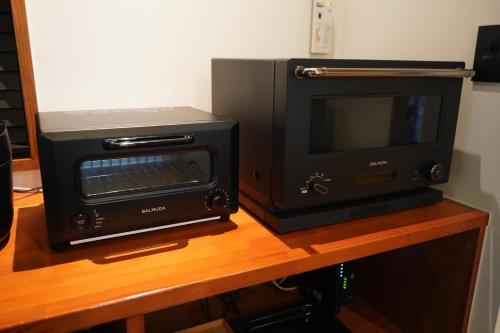 a microwave and a toaster oven on a table at COCO VILLA Yatsugatake in Hokuto