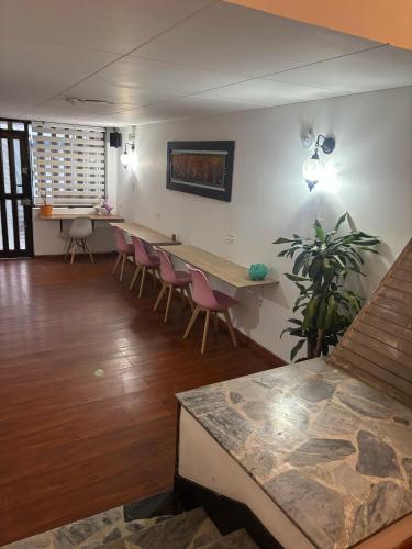 a living room with a long table and chairs at Kuyay Yachi Hostel in Bogotá