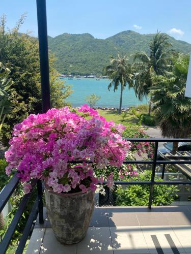 a pot of pink flowers on a balcony with a view at M Villa Nha Trang in Nha Trang