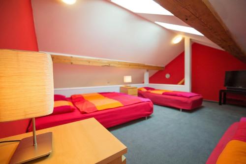 two beds in a room with red walls at Apartma Panorama Jeseník in Jeseník