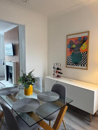 a dining room with a glass table and chairs at Gertrude house in Saint Helens
