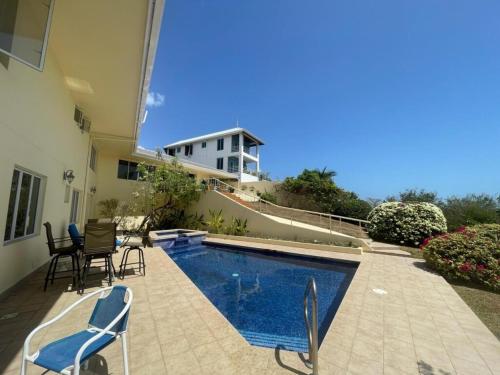 una piscina con sedie e una casa di Sikse 3BR 4bath with pool villa a Scarborough