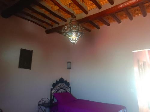 a room with a purple couch and a chandelier at Lamtounipalace in Ouarzazate