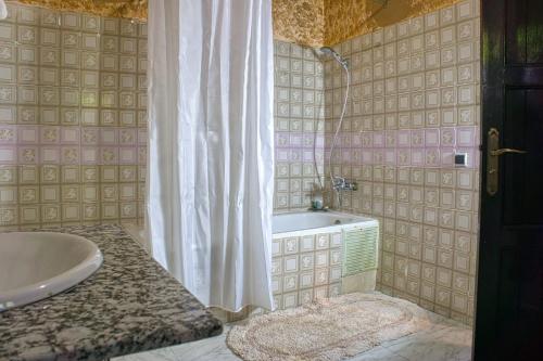 a bathroom with a tub and a sink and a shower at Lamtounipalace in Ouarzazate