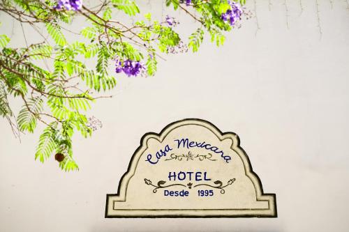 a sign for a hotel on a wall with flowers at Hotel Casa Mexicana in Mineral de Pozos