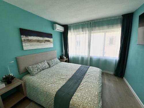 a bedroom with a bed with blue walls and a window at Tiffany Lovely New Apartment 51 in Estepona