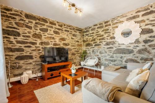 a living room with a stone wall at Sea View Villa by Homie in Santa Cruz