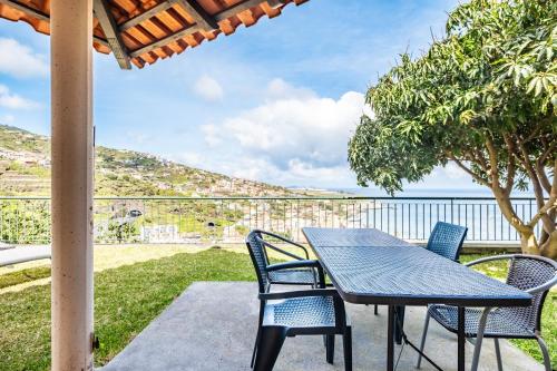 a table and chairs on a patio with a view of the ocean at Sea View Villa by Homie in Santa Cruz