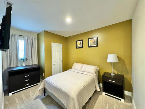 a bedroom with a bed and a dresser and a window at Home in Downtown Concord in Concord