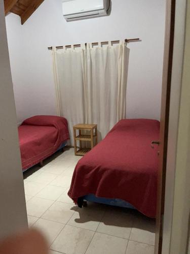 a bedroom with two beds and a red blanket at Cabañas Paz in Carpintería